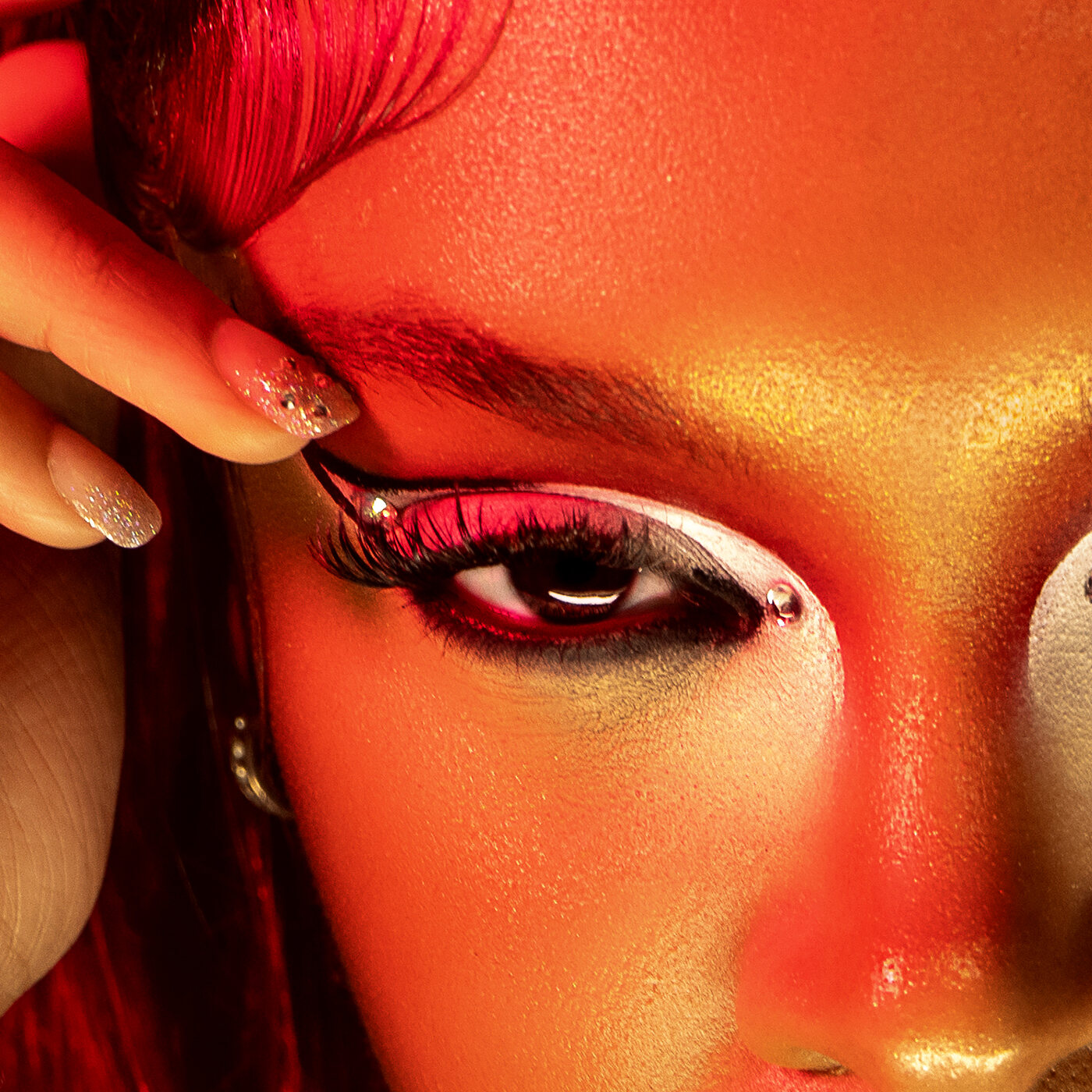 Beauty close-up with red petals and metallic eye makeup